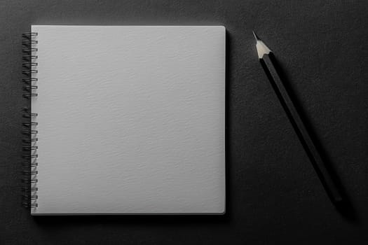 A clean minimalist notebook sits alongside a sharpened pencil on a dark background, inviting creativity and fresh design concepts. This setup is perfect for brainstorming sessions or sketching.