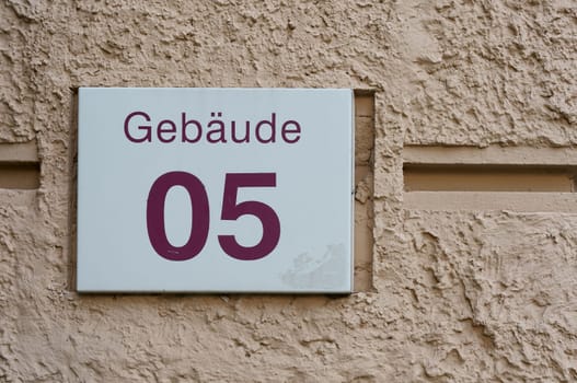 Sign with the German inscription Gebaude 05 on the facade of an administrative building. Translation: Building 05