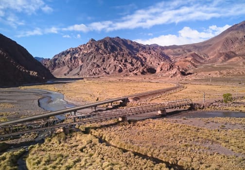 Bridge across Mendoza River by the Andes mountains near Uspallata, Argentina. Aerial view.