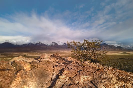 Rocky outcrop with the snowcapped Andes mountains in the distance near Uspallata, Argentina.