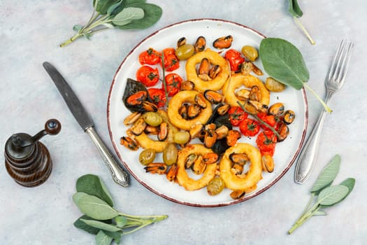 Delicious baked mussels and squid rings with sage. Exotic seafood platter. Space for text.