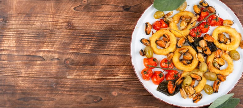 Delicious baked mussels and squid rings with sage. Exotic seafood platter. Space for text.