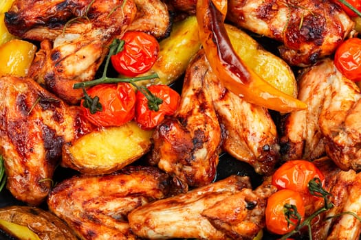 Freshly baked chicken wings with marble potatoes and sage. Space for text.