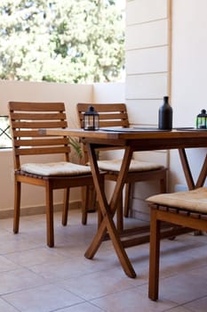 private balcony with wooden chairs and table. vertical shot