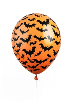 A close up of an orange Halloween balloon decorated with black bats.