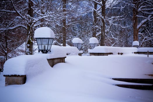 White landscape: snowy lamps near house in the woods.ÊToned and vignetted image as postcard