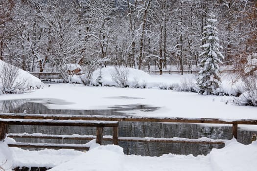 Fairy tale.ÊSnowy Alpine house and frozen river in the woods.ÊToned and vignetted image as postcard