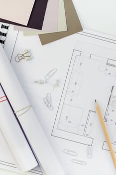 Creative flat lay overhead top view blueprints architectural flat project plan and office supplies on decorator white table workspace with swatches tools and equipment background copy space concept