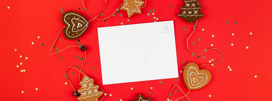 Creative New Year or Christmas greetings letter mockup flat lay top view Xmas holiday celebration envelope on red paper background golden glitter. Template mock up long wide banner 2020
