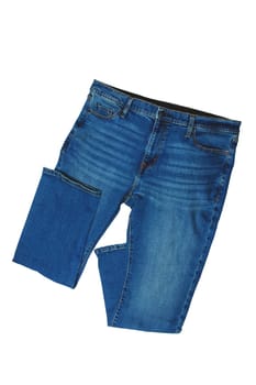 Jeans isolated. Folded trendy stylish blue denim stretch pants or trousers for men isolated on a white background. Clipping path. Jeans summer and autumn fashion.