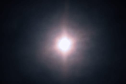 Full moon in the night sky sends amazing glowing light into the night sky. Full moon background texture. Macro.