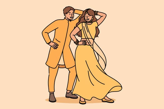 Indian couple performs ritual mating dance, moving rhythmically to oriental music. Newlyweds in indian national clothes dance while performing in front of audience at ethnic festival
