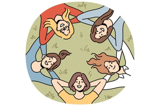 Group of girls lies on grass and looks up smiling enjoying vacation in park in hot summer weather. Friendship between young women relaxing in park after graduation from college from university