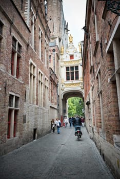 BELGIUM, BRUGES - MAY 26, 2015: Tourists on the narrow street of old Bruges, Belgium