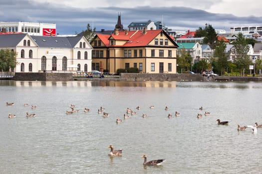 ICELAND, REYKJAVIK - AUGUST 20, 2012: Reykjavik cityscape viewed from across the Tjornin lake in the center of Iceland capital city