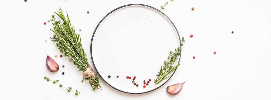 Flat lay overhead view empty plate mockup blank text space invitation card on white background with greens herbs and spices. Menu design food background with cooking ingredients