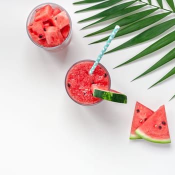 Creative scandinavian style flat lay top view of fresh watermelon slices smoothie drink in glass on white table background copy space. Minimal summer fruits concept for blog or recipe book