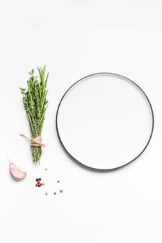 Flat lay overhead view empty plate mockup blank text space invitation card on white background with greens herbs and spices. Menu design food background with cooking ingredients