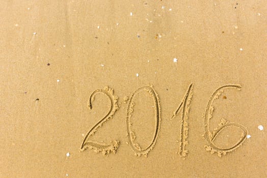 2016 Year written on the beach. sand background