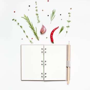 Flat lay overhead view blank notebook pages mockup text space invitation card on white background with greens herbs and spices. Menu or recipe book or food blog design with cooking ingredients