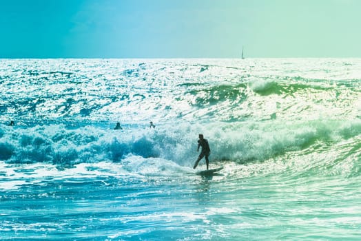 Extreme surfers riding some waves on the sea in France