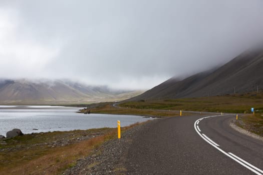 Highway through Iceland landscape at overcast day. Horizontal shot