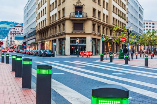 City centre in Bilbao, Spain with modern traffic lights posts on pedestrian crossing