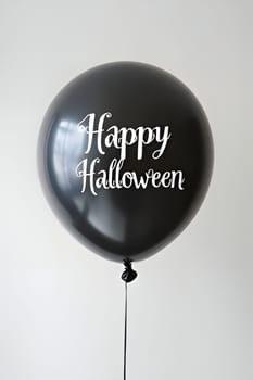 A single black balloon with a white 'Happy Halloween' greeting, perfect for a spooky celebration.