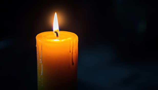 Burning candle flame in the dark. Concept of memory, hope, grief, and remembrance.