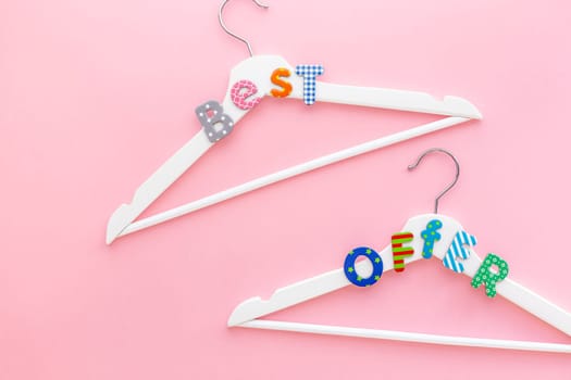 Creative top view flat lay white wooden hangers best offer pastel pink background copy space minimalism style. Template fashion feminine blog social media sale store promo design shopping concept