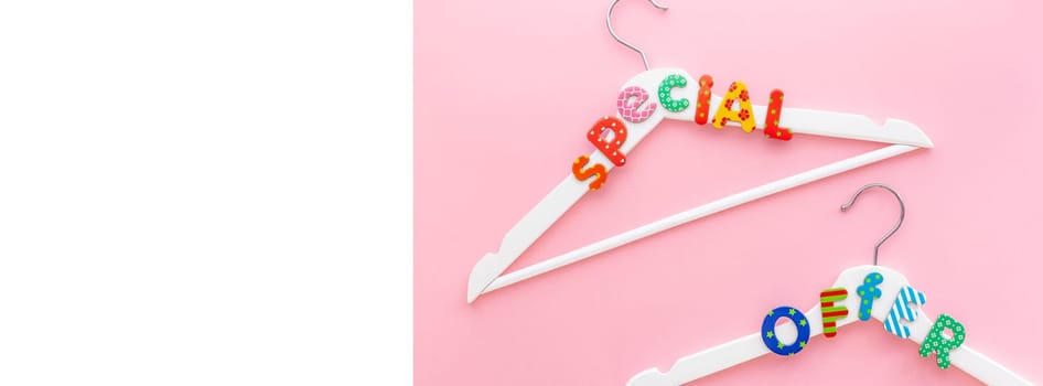 Creative top view flat lay white hangers special offer text pastel pink background copy space minimalism style. Template fashion feminine blog social media sale store promo design shopping concept