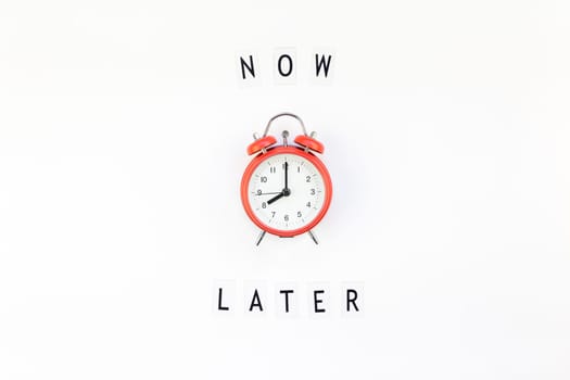 Creative top view flat lay of alarm clock with messages about delay or starting doing task copy space white background minimal style. Concept of procrastination, time management in business and life