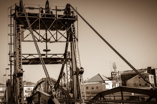 Metal structure elevation bridge over Sado river. Alcacer do Sal, Portugal. Sepia filtered shot