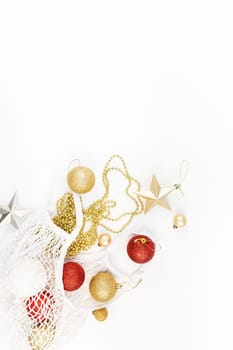Christmas composition. New Year or Christmas flat lay top view Xmas holiday decorative golden toys in eco-friendly shopping mesh bag on white background with copy space. Template of greeting card