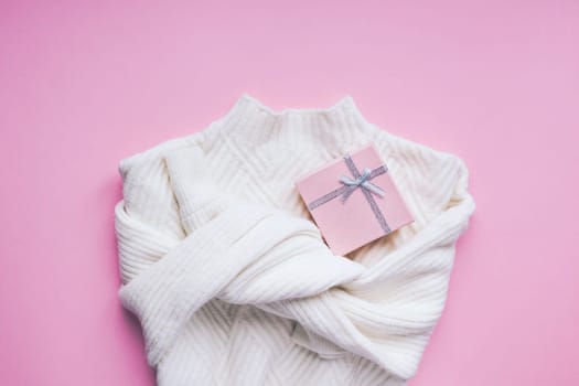 Creative valentine's day romantic flat lay overhead top view white sweater and gift box on pink background copy space minimal style with natural light. 14 February holiday template for feminine blog