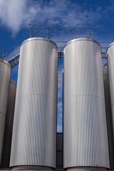 Giant industrial tanks on the bright blue sky background