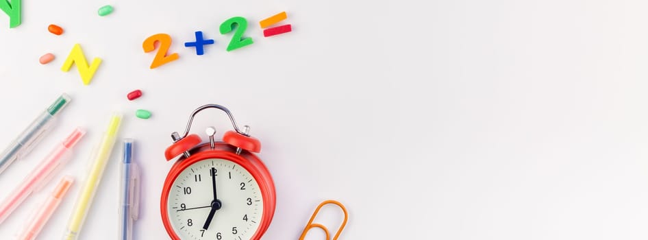 Long wide banner back to school concept with alarm clock, color school and office supplies on white table background with copy space, frame, template for text or design