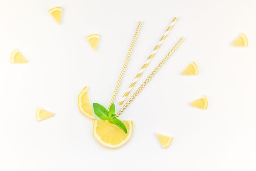 Creative flatlay overhead top view citrus lemon slices and mint herbs leaves white table background with copyspace. Hot summer refreshment lemonade concept. Beverage ingredients arranged with straws