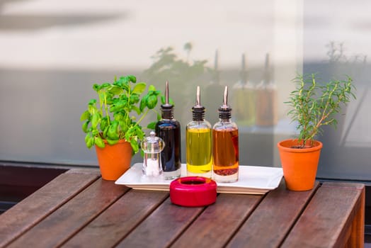 Balsamic vinegar and oil bottles and condiments on the table in an outdoor cafe