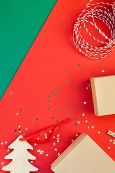 New Year or Christmas presents preparation DIY flat lay top view Xmas holiday celebration handmade gift boxes on red green paper background. Template mockup for greeting card or your text design 2019