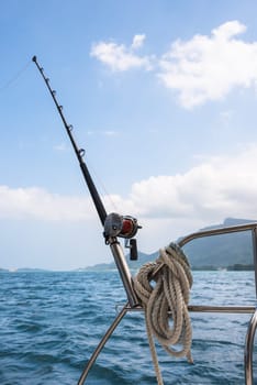 Fishing rod and reel on a sailing yacht. Vertical shot