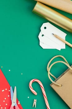 New Year or Christmas presents preparation DIY flat lay top view Xmas holiday celebration handmade gift boxes on red green paper background. Template mockup for greeting card or your text design 2019