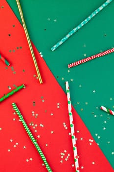New Year or Christmas pattern flat lay top view Xmas holiday celebration drinking cocktail party straws red green paper golden sparkles background. Template 2019 for greeting card your text design