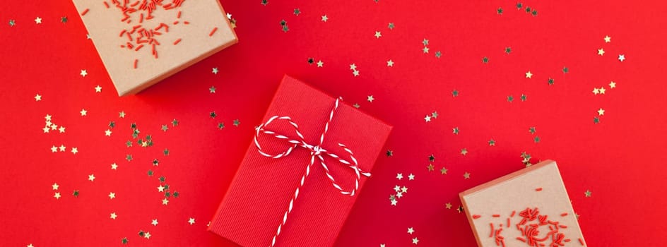 New Year or Christmas presents wrapped ribbon flat lay top view Xmas holiday 2019 celebration handmade gift boxes red paper golden sparkles background. Template mockup greeting card long wide banner