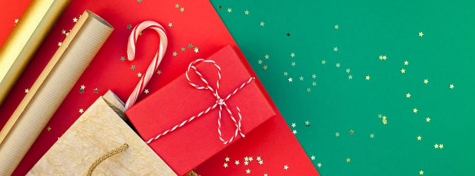 New Year or Christmas presents preparation DIY flat lay top view Xmas holiday celebration handmade gift boxes on red green paper background. Template mockup for greeting card long wide banner 2019