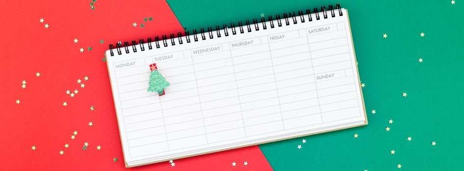 Creative New Year or Christmas timetable event planner mockup flat lay top view Xmas holiday celebration holiday schedule on red green paper background. Template mock up long wide banner 2019 2020