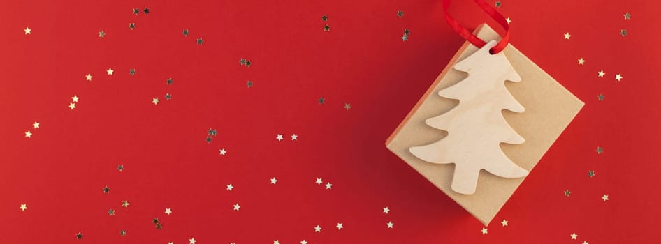 New Year or Christmas present flat lay top view Xmas 2019 holiday celebration handmade gift box red paper golden sparkles background copyspace. Template mockup for greeting card long wide banner