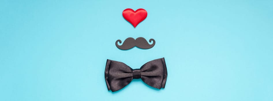 Creative flatlay overhead top view retro stylish black paper moustaches bow tie red heart turquoise background copy space. Men health awareness month fathers day masculinity concept long wide banner