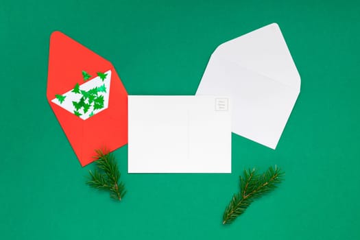 Creative New Year or Christmas greetings letter mockup flat lay top view Xmas holiday celebration envelope on green paper background. Template mock up greeting card or your text design 2020