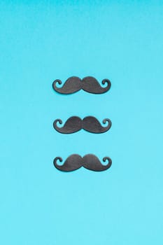Creative flatlay overhead top view retro stylish black paper photo booth props moustaches turquoise background copy space. Men health awareness month fathers day masculinity concept blog social media